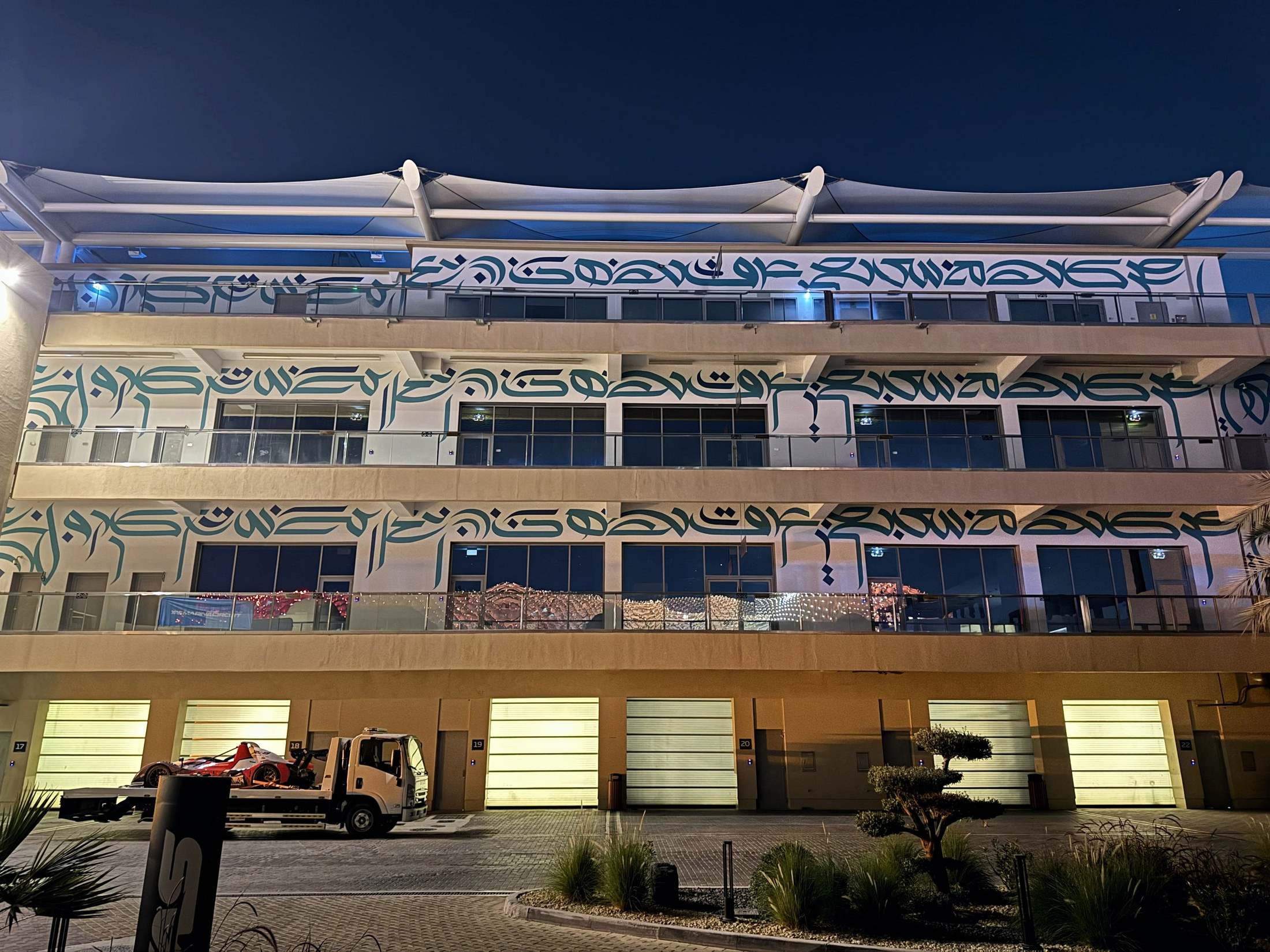 Hand-painted mural across the Yas Marina Circuit Paddock Club facade at night